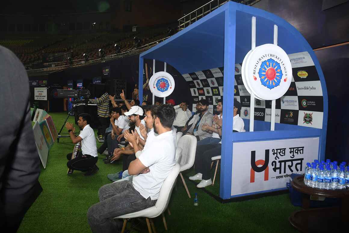 RCL Season 3 team dugout with Hunger Free Bharat branding and cheering players